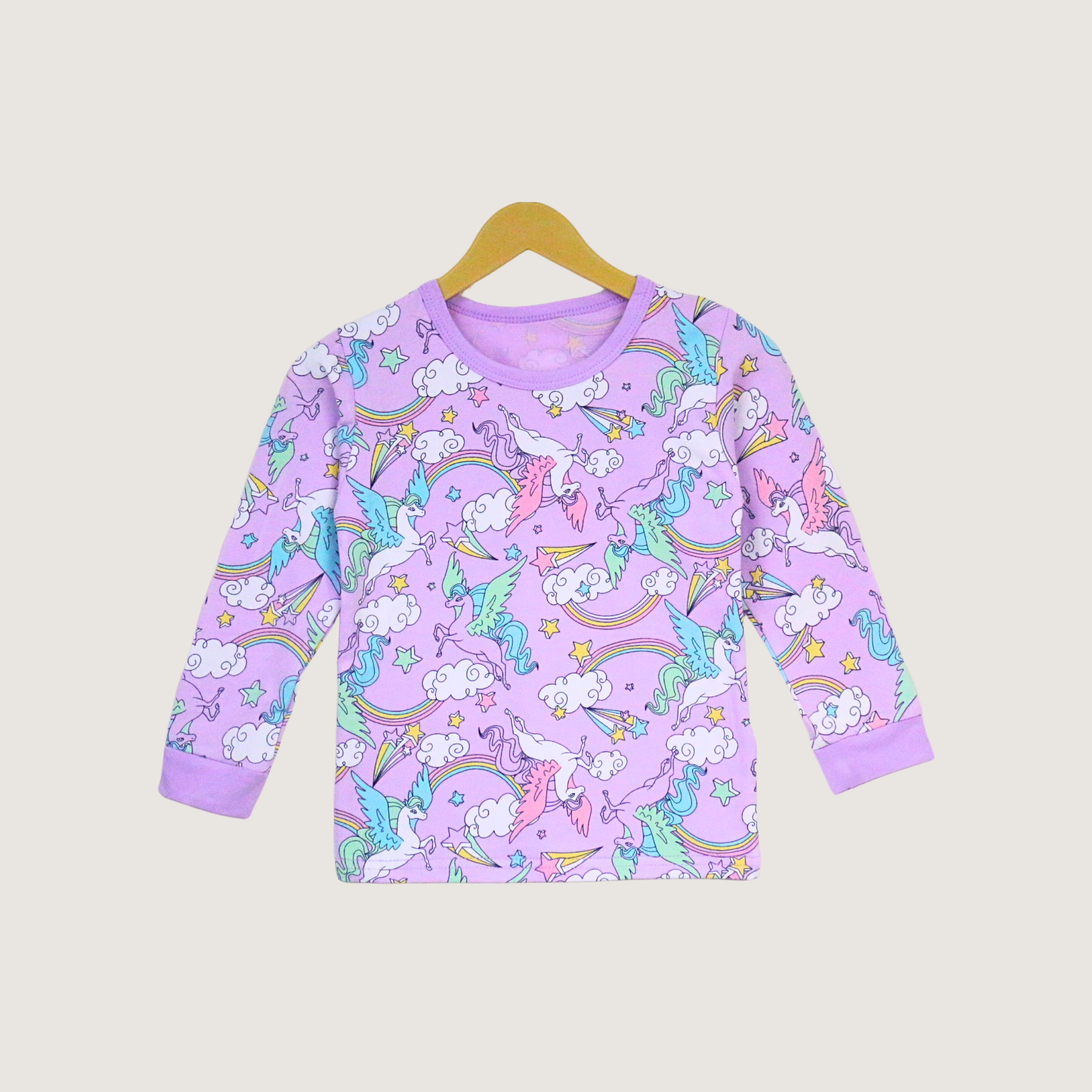 Purple long-sleeve shirt with unicorn and rainbow pattern on a beige background