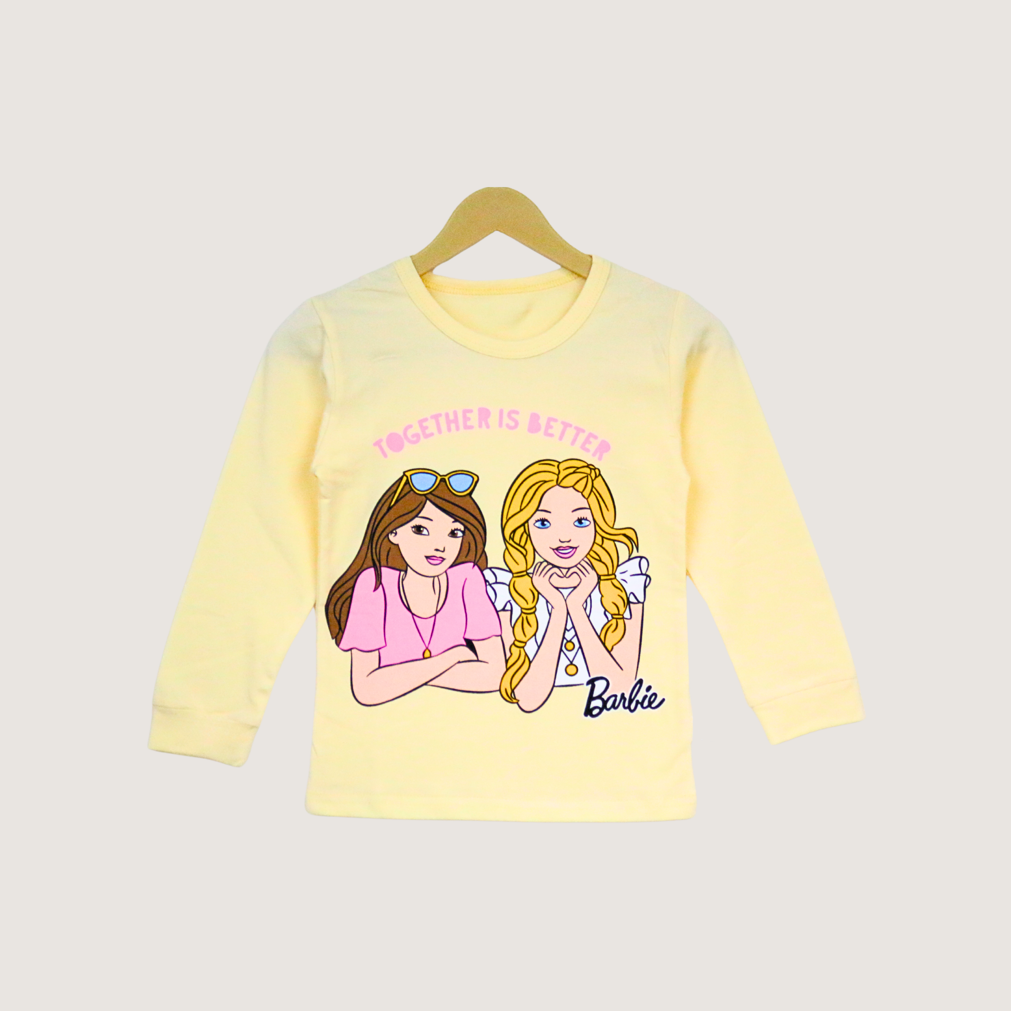 Yellow long-sleeve shirt with Barbie-themed design on a white background