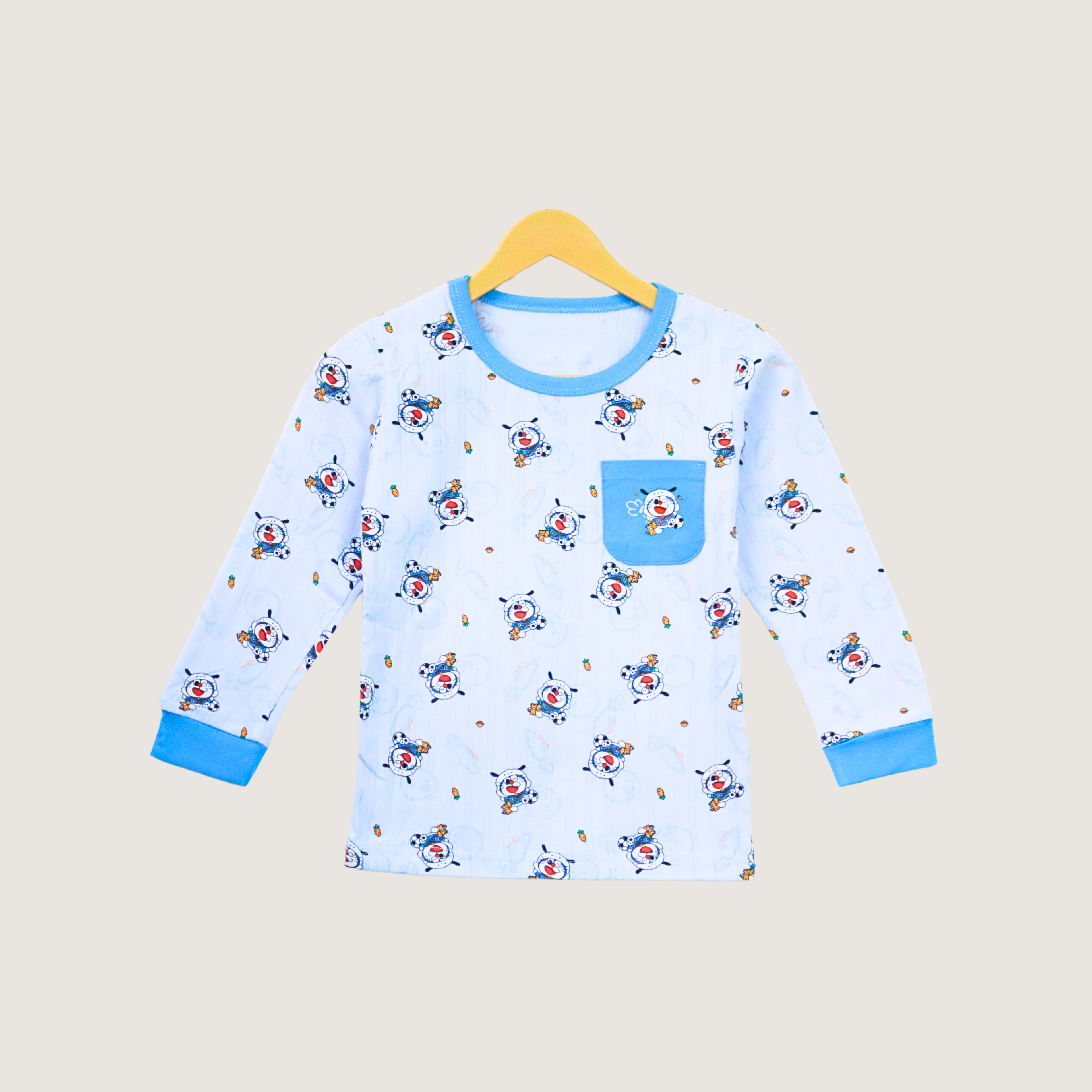 Children's blue pajama top with cartoon pattern on a beige background