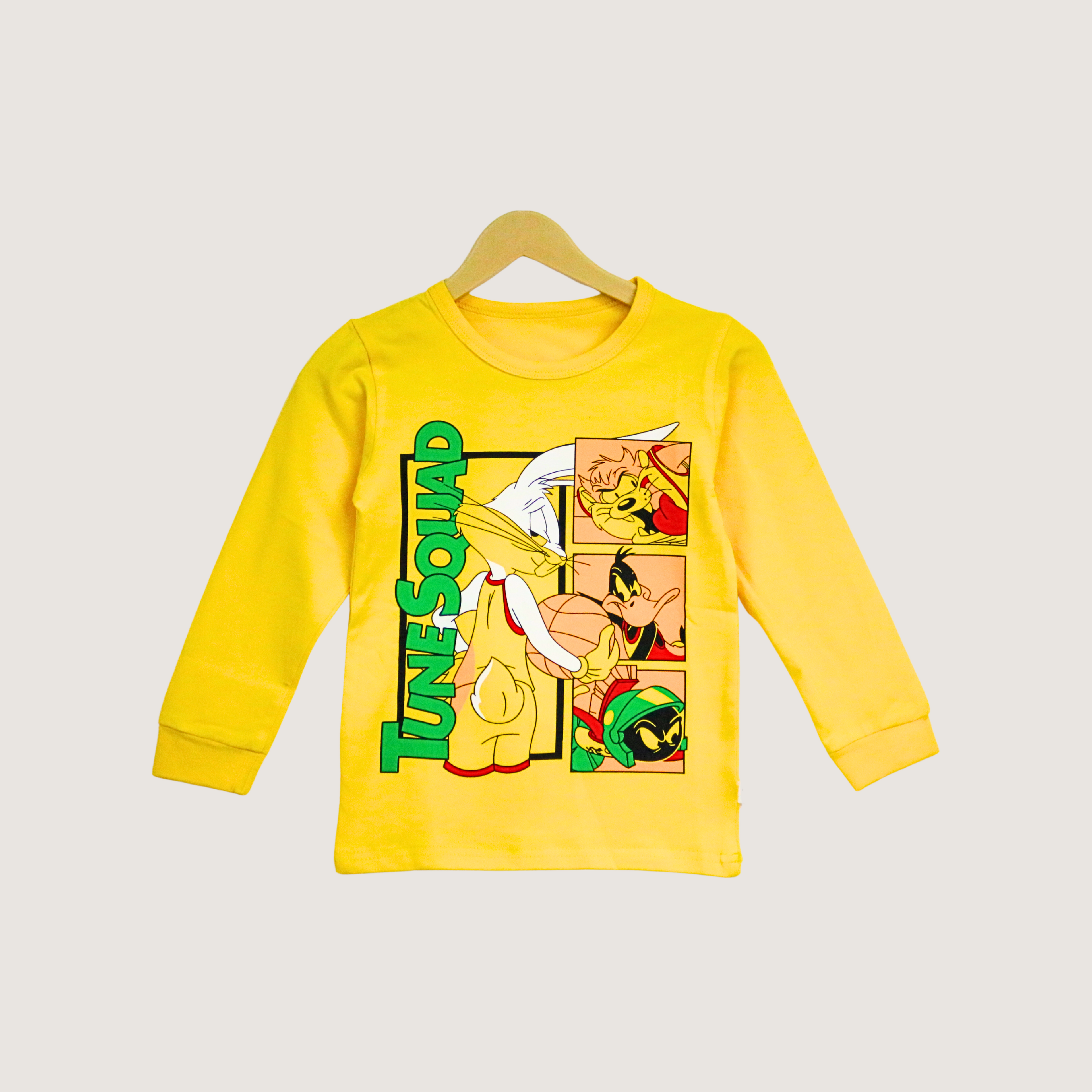 Yellow long-sleeve shirt with 'Tunesquad' graphic on a hanger against a light gray background