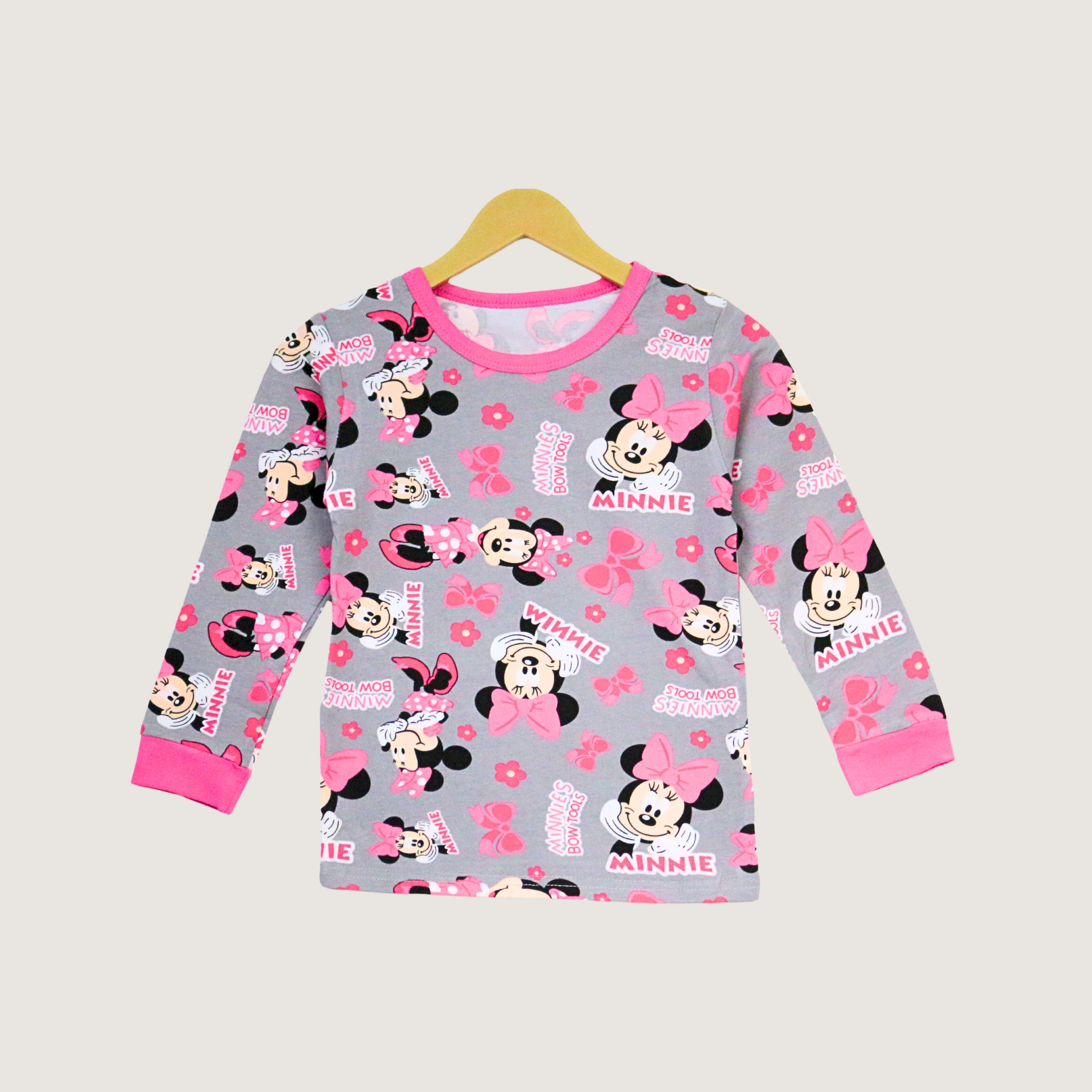 Children's long-sleeve shirt with Minnie Mouse pattern on a hanger against a light gray background