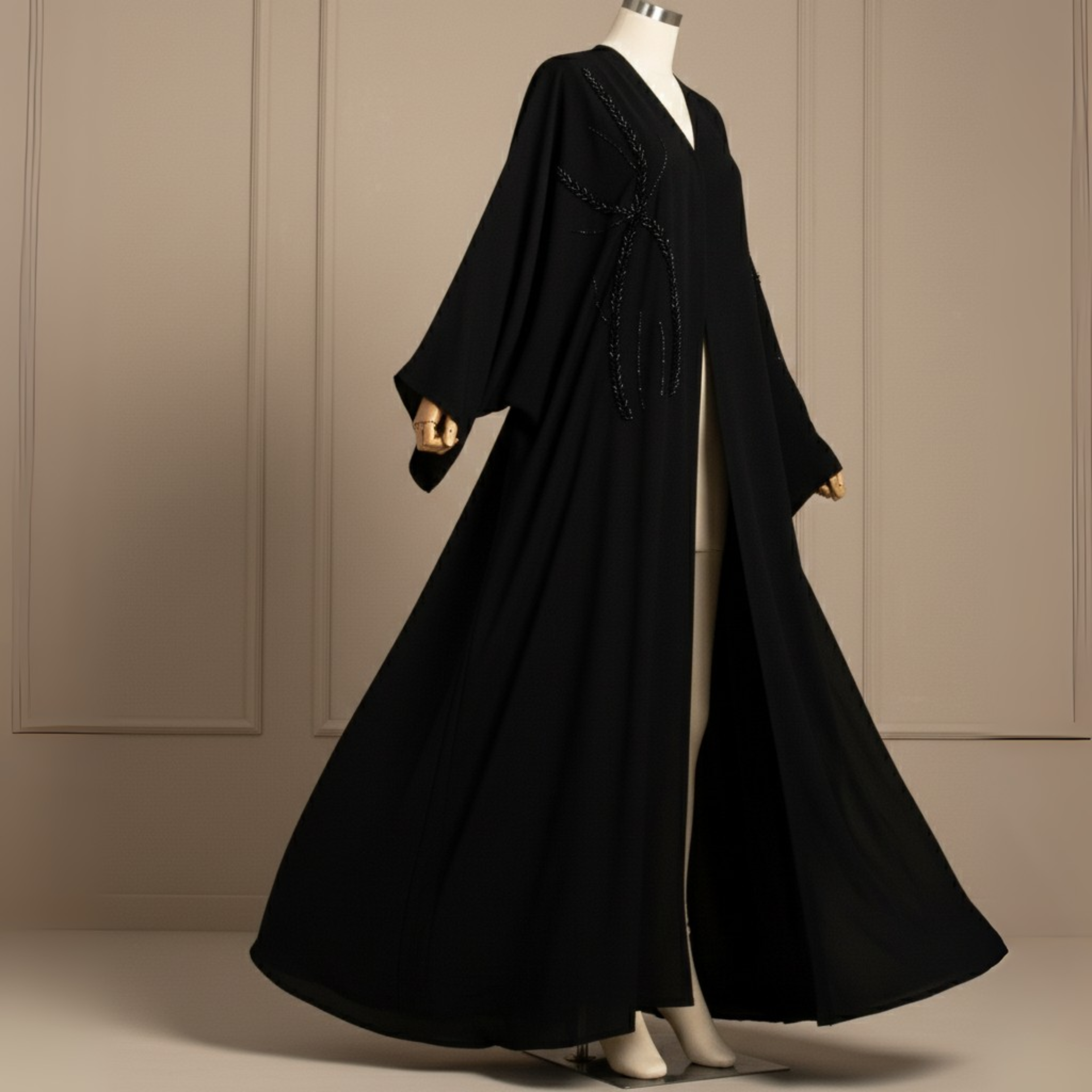 Black abaya on a mannequin against a beige wall.