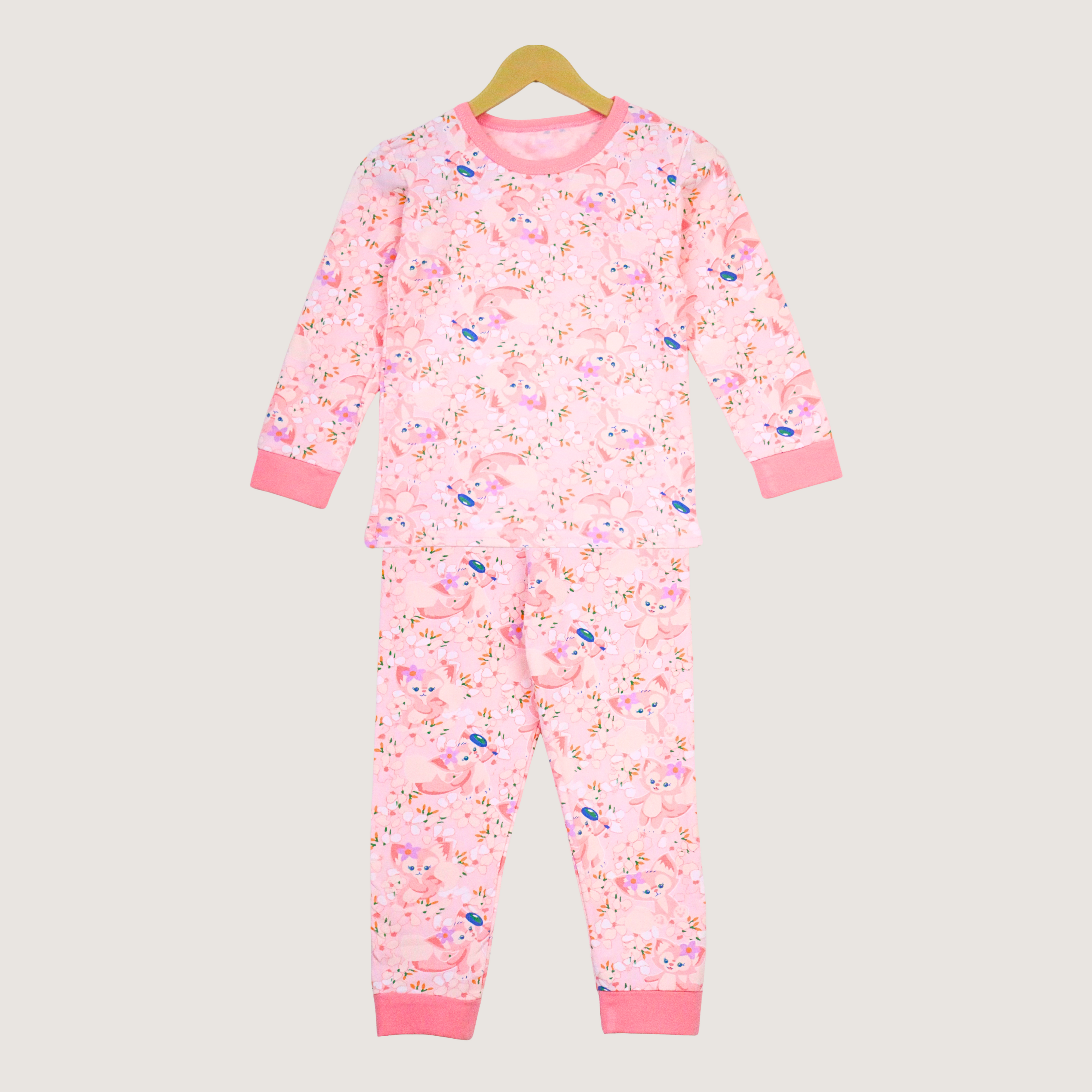 Pink children's pajama set with a floral pattern on a beige background