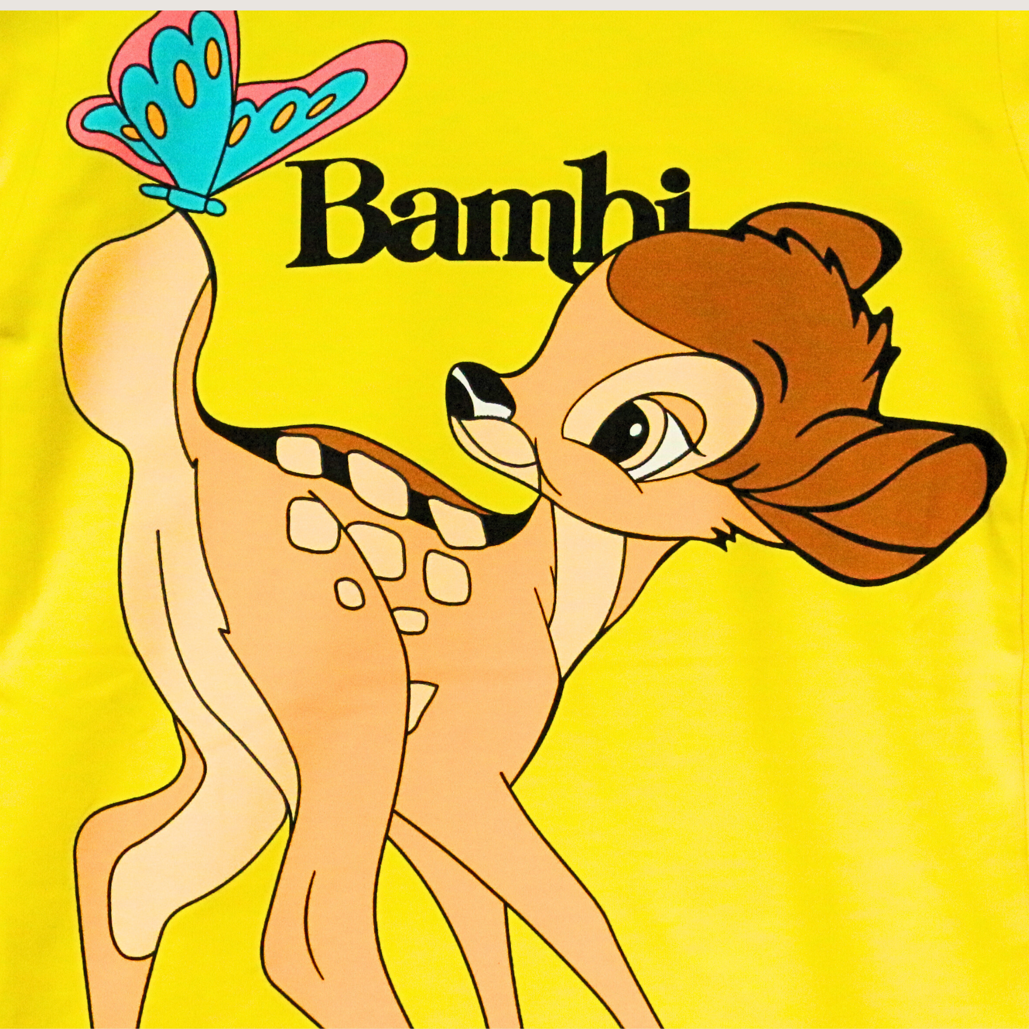 Animated deer character from 'Bambi' with a butterfly on a yellow background