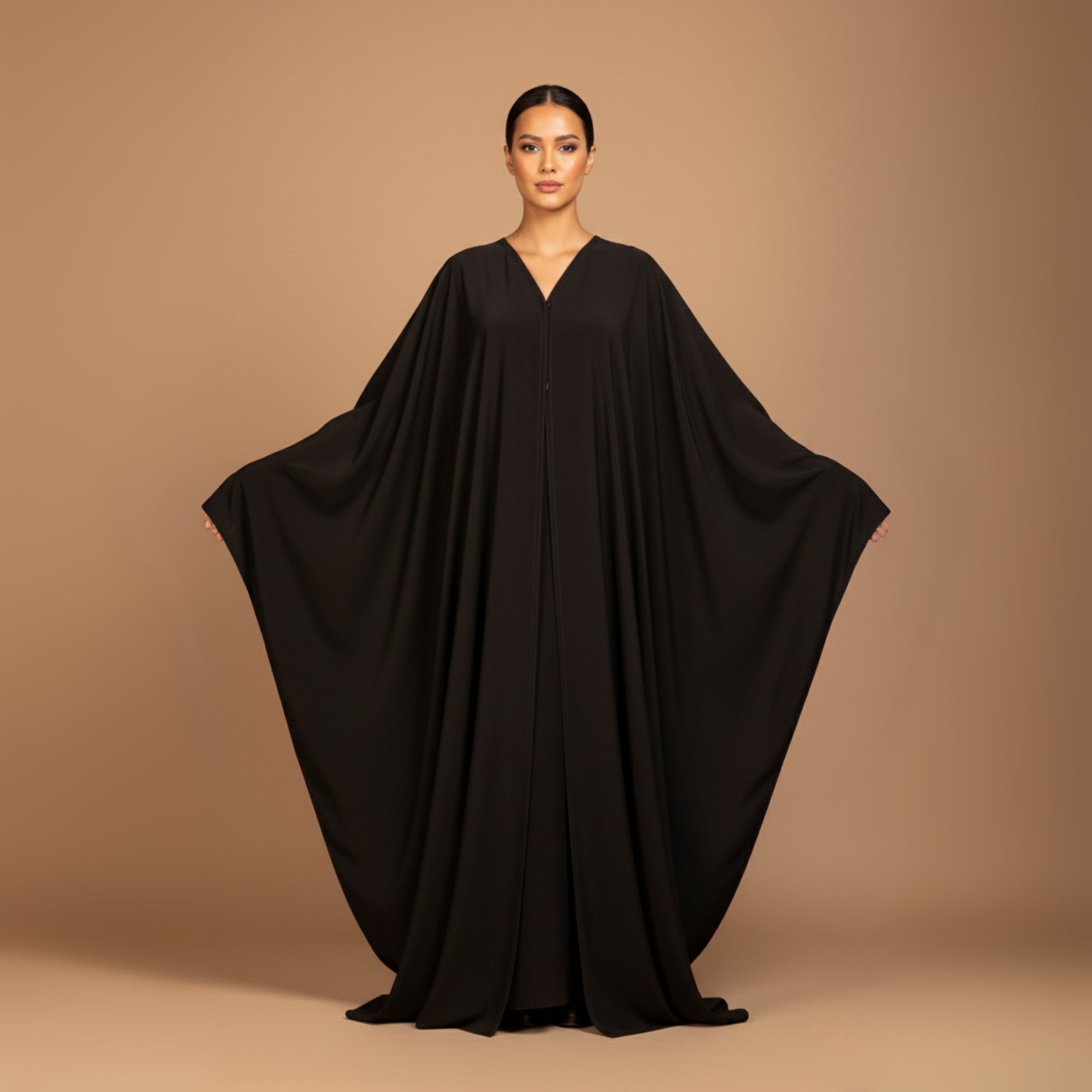 Woman wearing a black flowing dress against a beige background