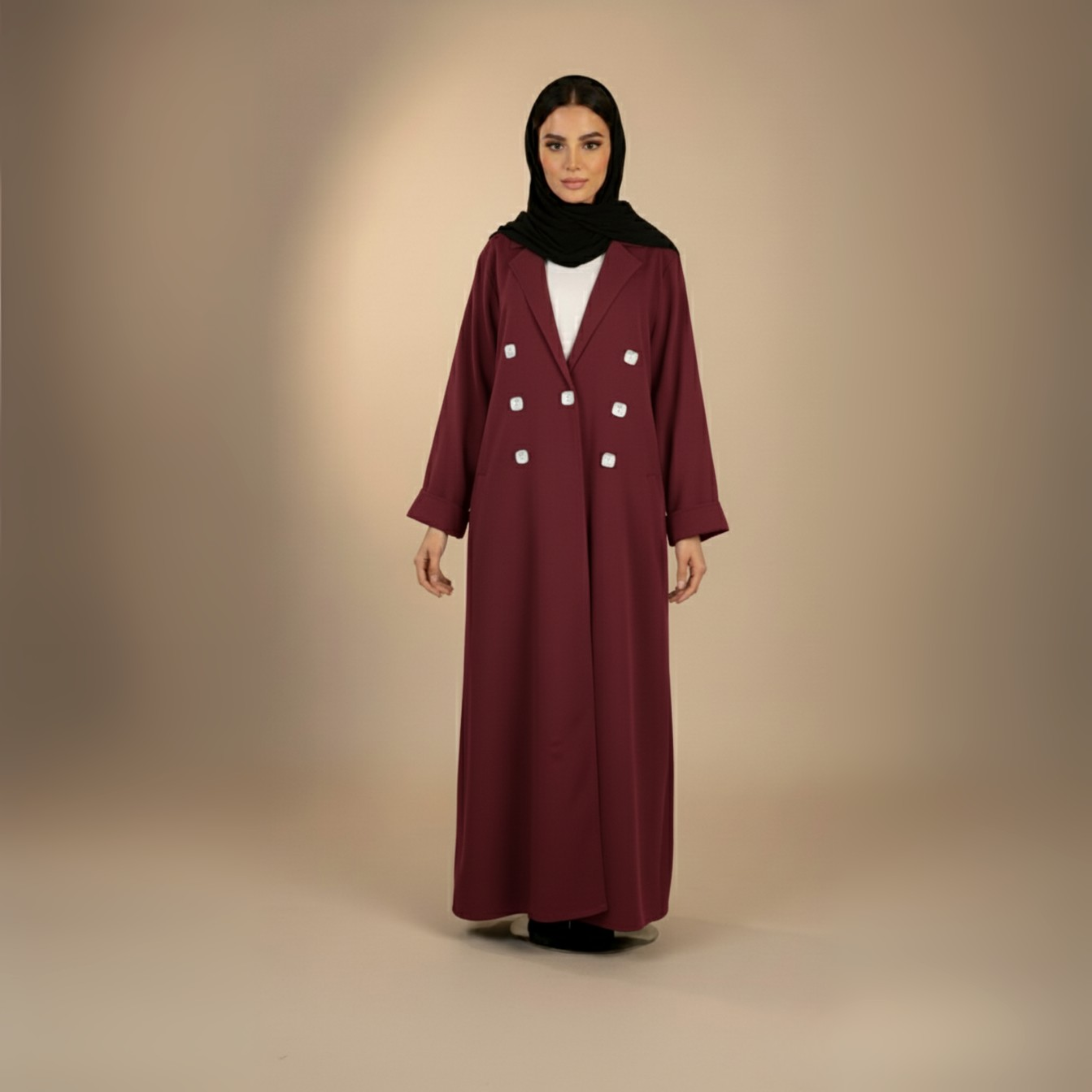 Woman wearing a burgundy coat with white buttons on a beige background