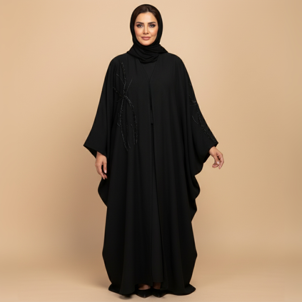 Woman wearing a black abaya on a beige background