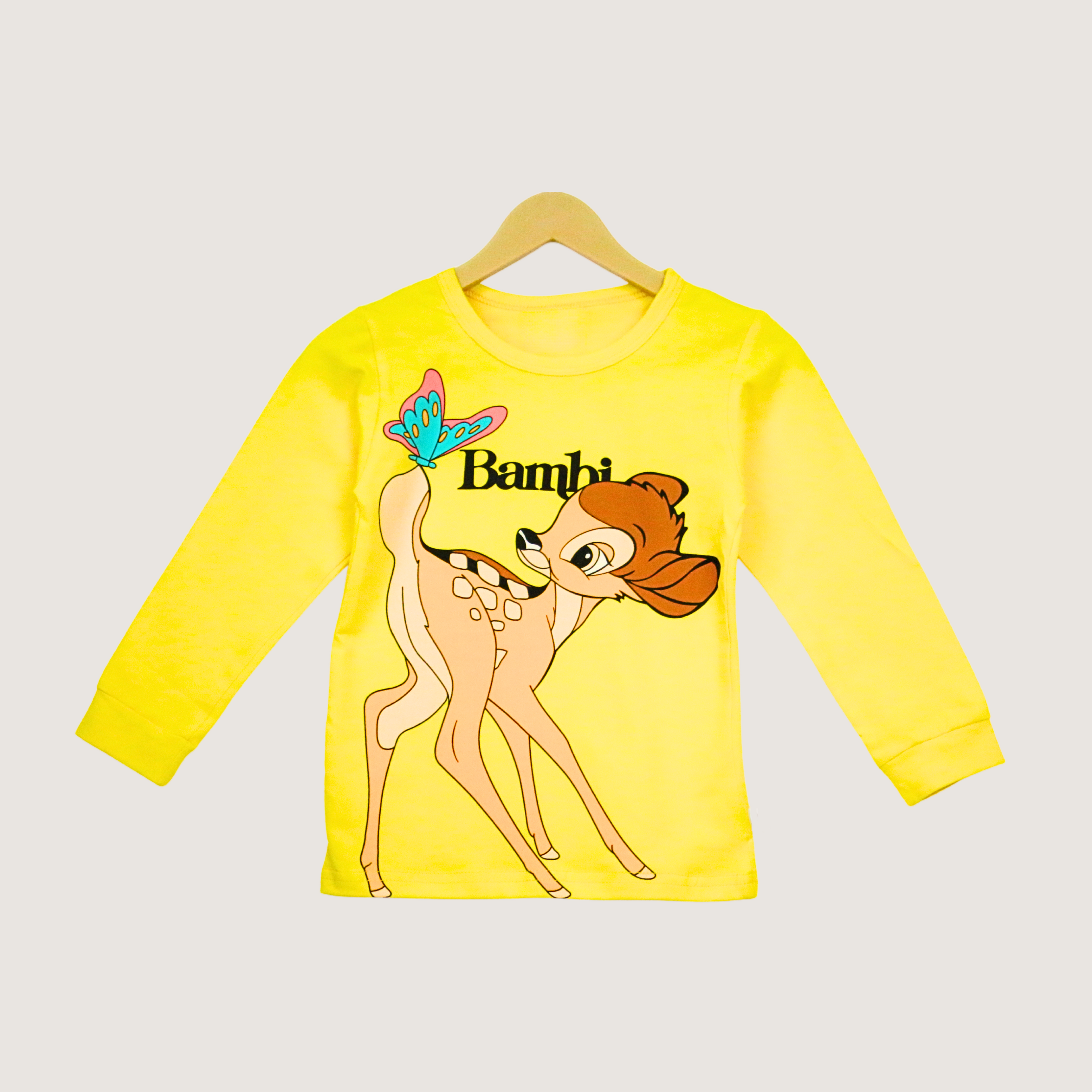 Yellow long-sleeve shirt with Bambi character on a hanger against a light gray background