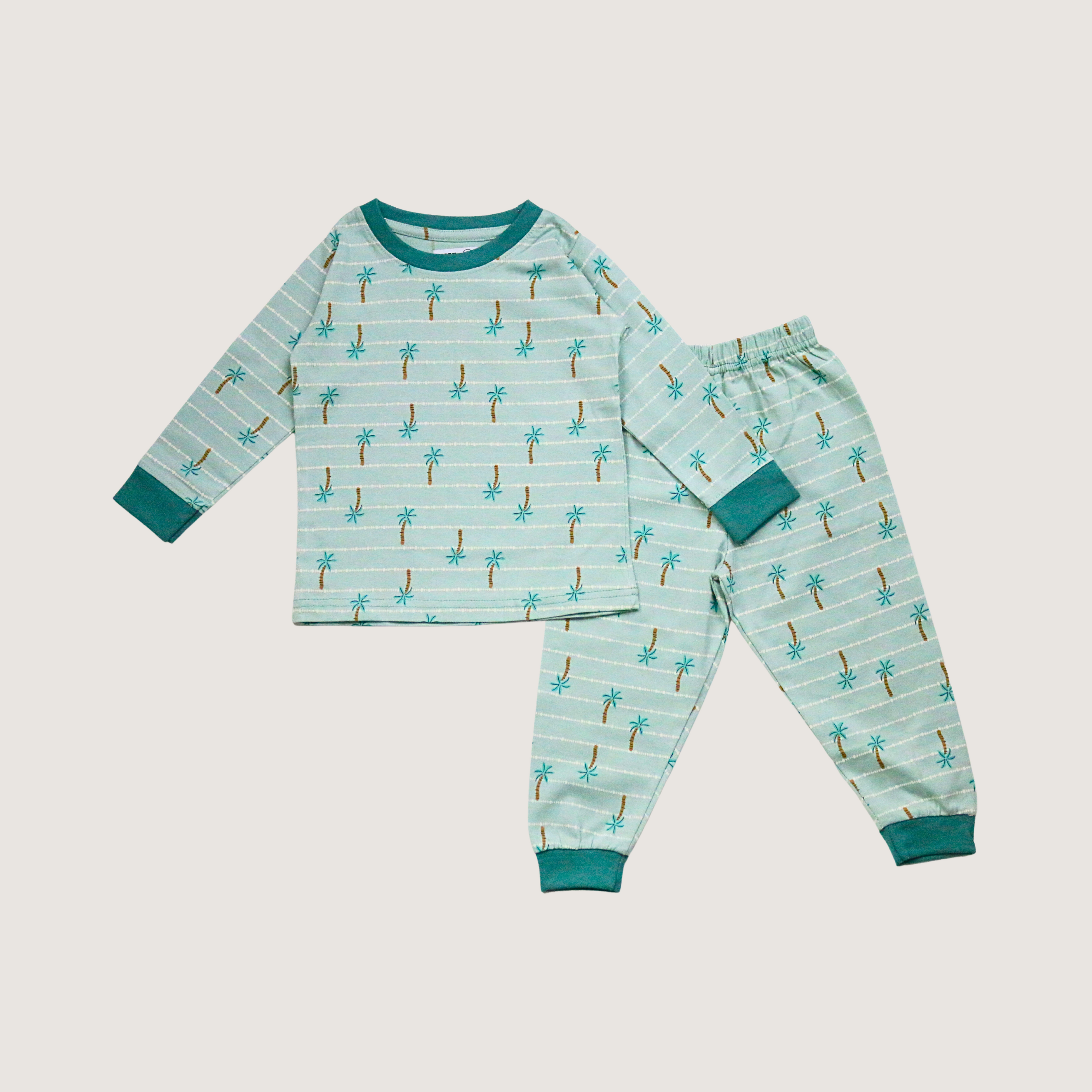 Children's pajama set with palm tree pattern on a light blue background