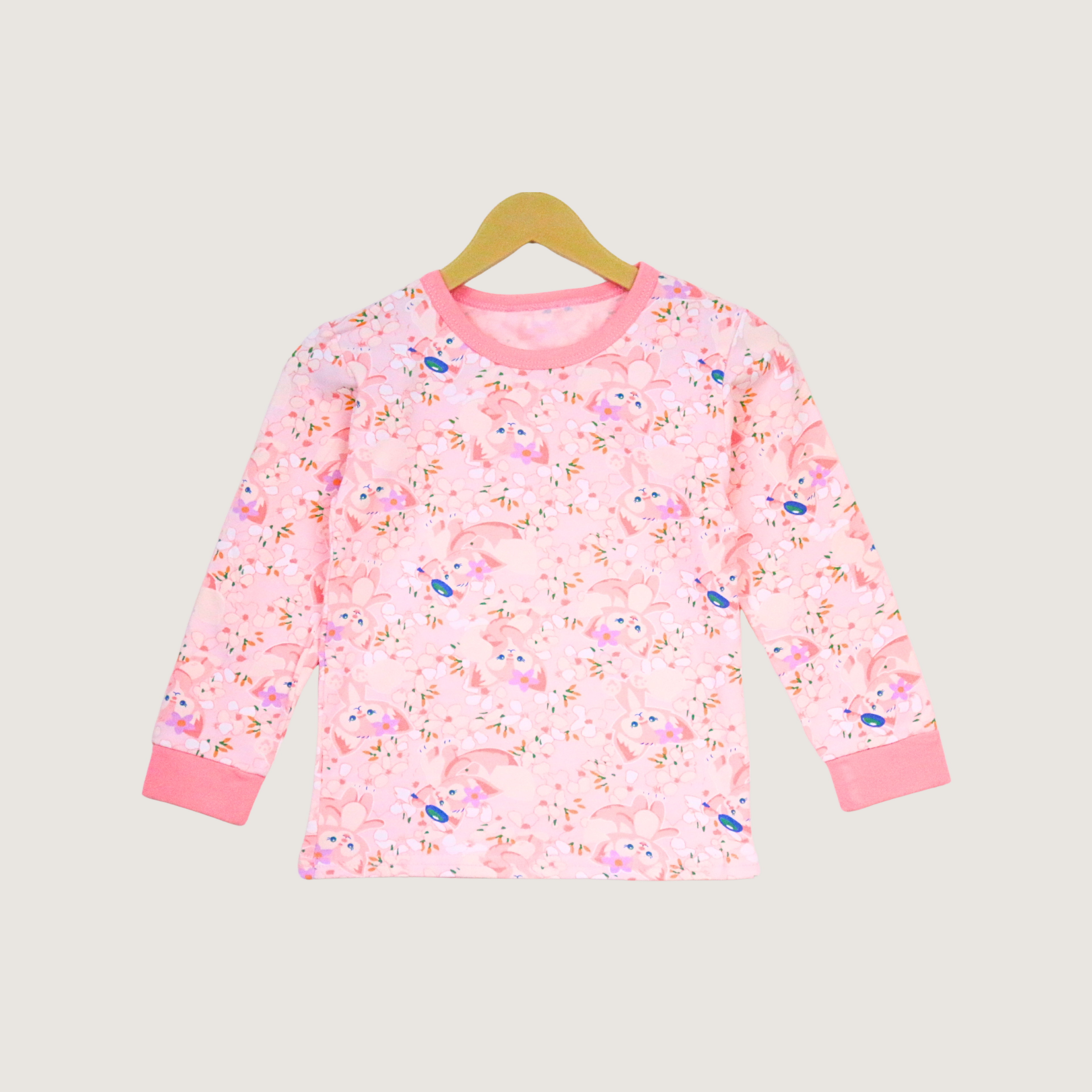 Pink children's long-sleeve shirt with a floral pattern on a beige background