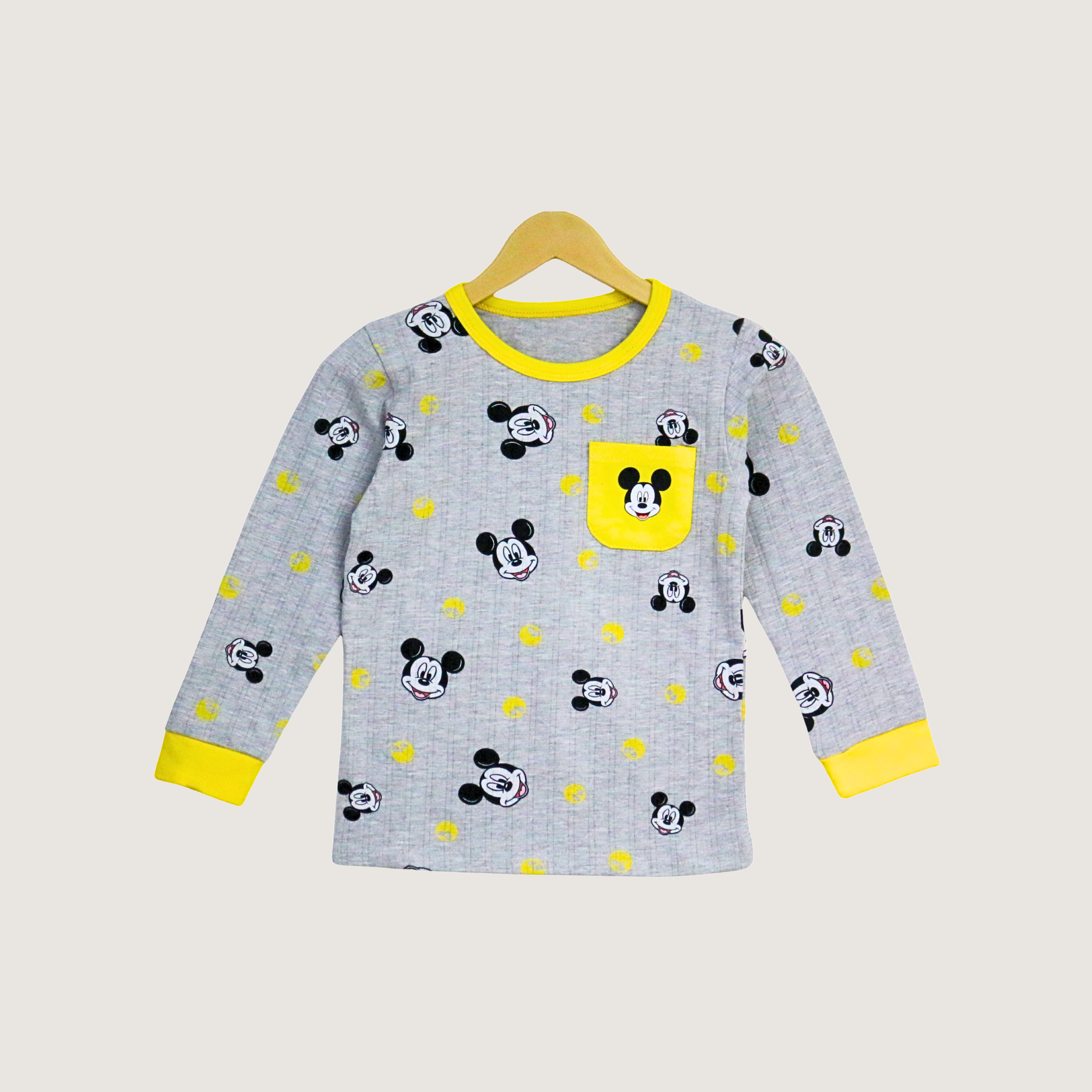 Children's long-sleeve shirt with Mickey Mouse pattern on a hanger against a beige background