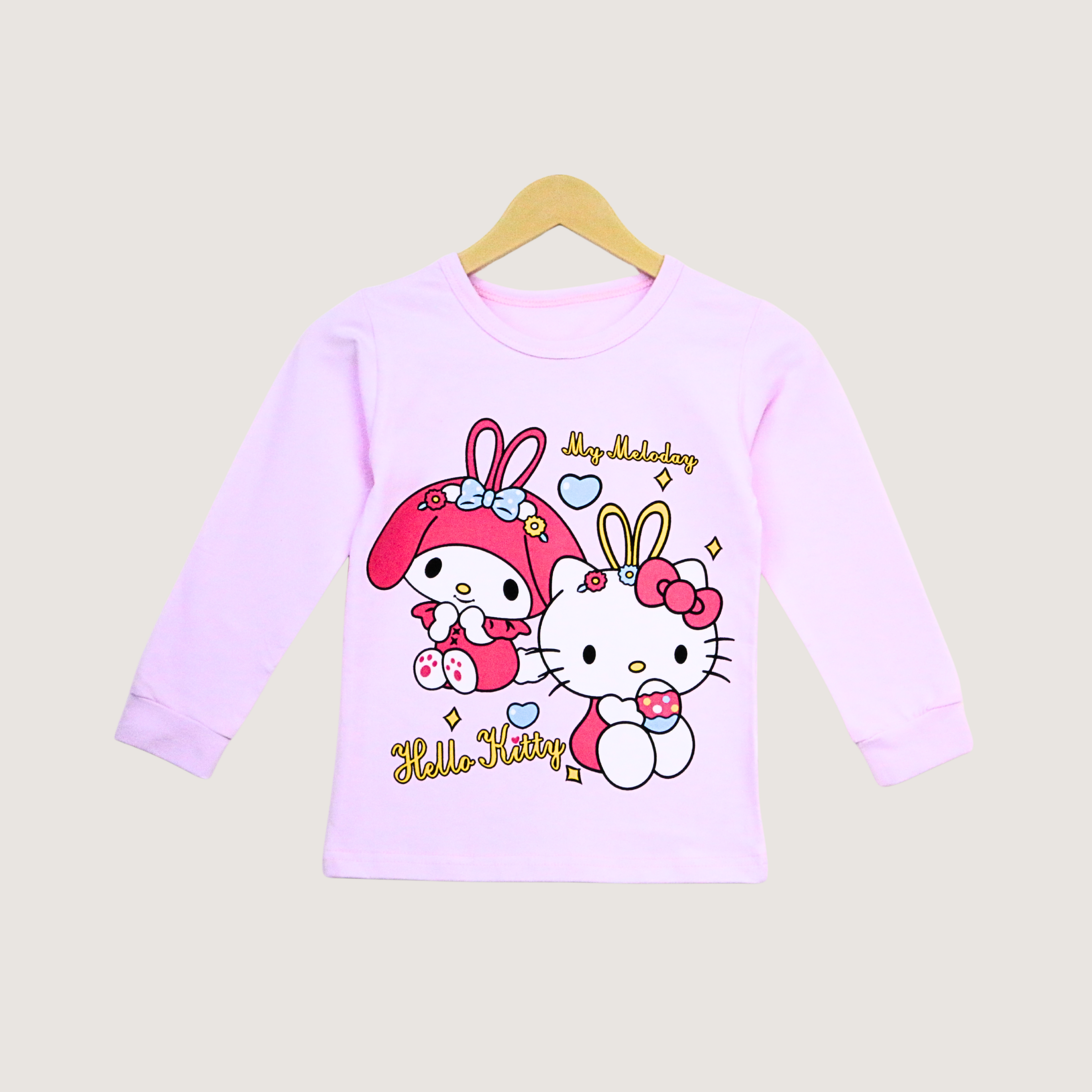 Pink long-sleeve shirt with Hello Kitty design on a beige background