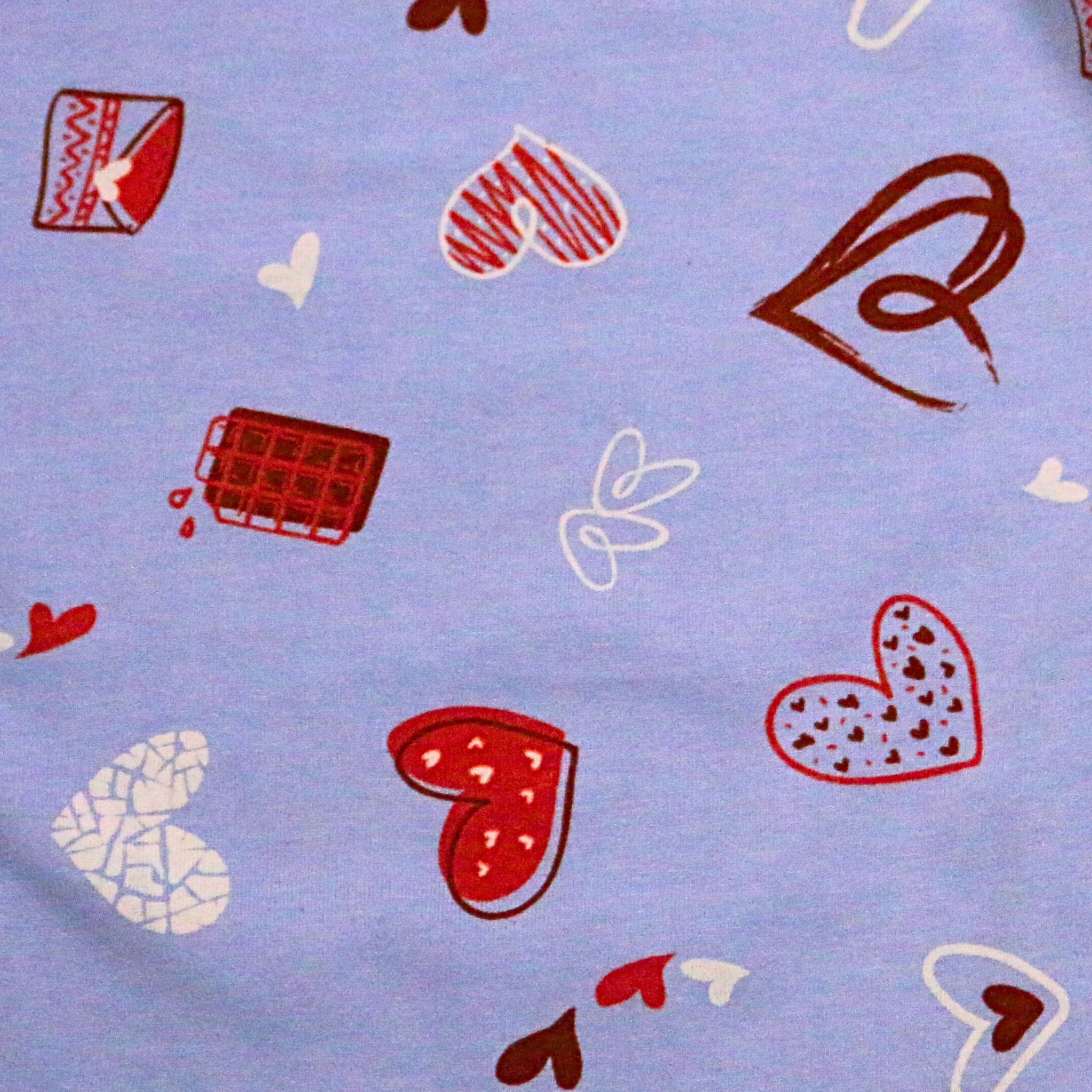 Pattern of red, white, and brown hearts on a light blue background