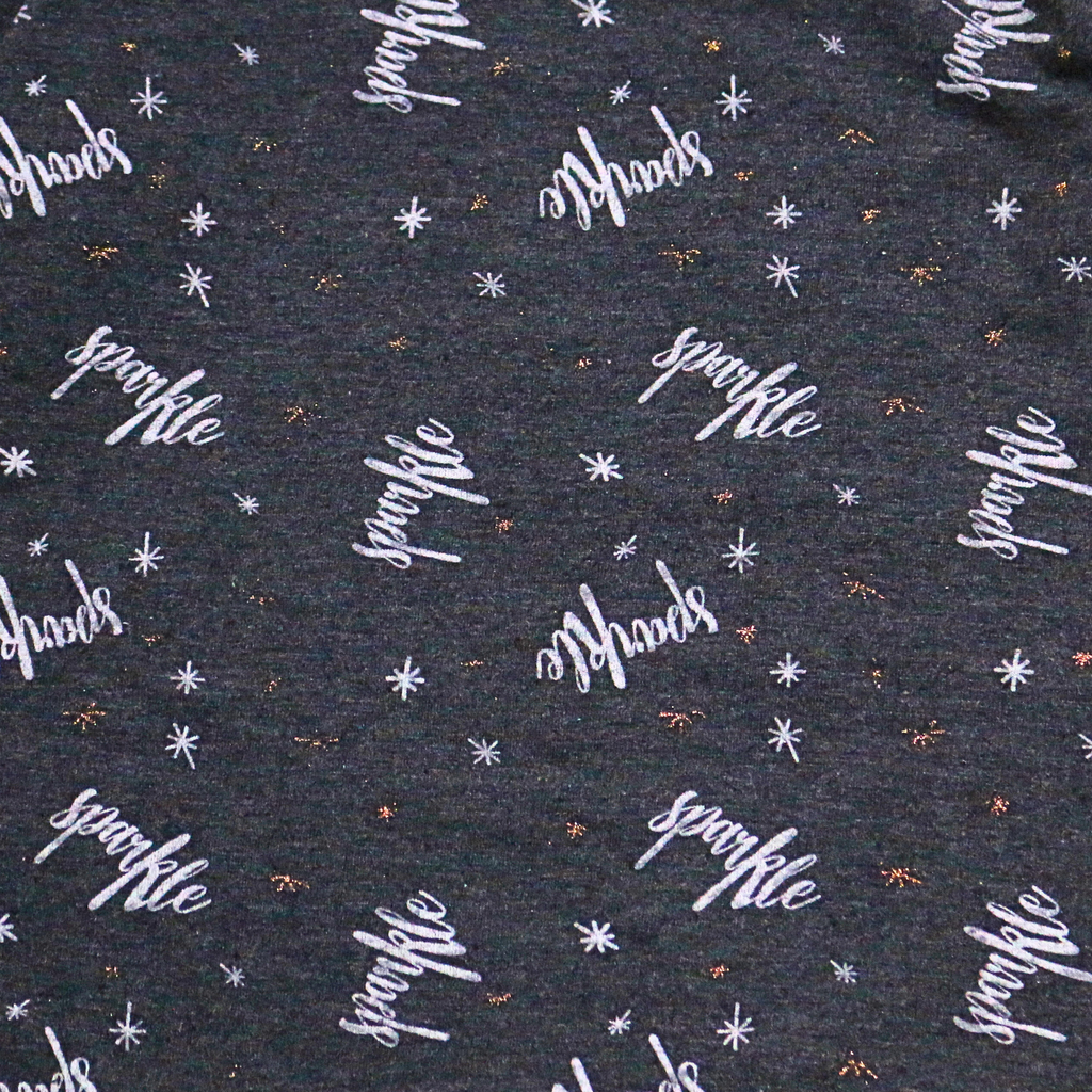 Patterned fabric with 'sparkle' text and star designs on a dark background