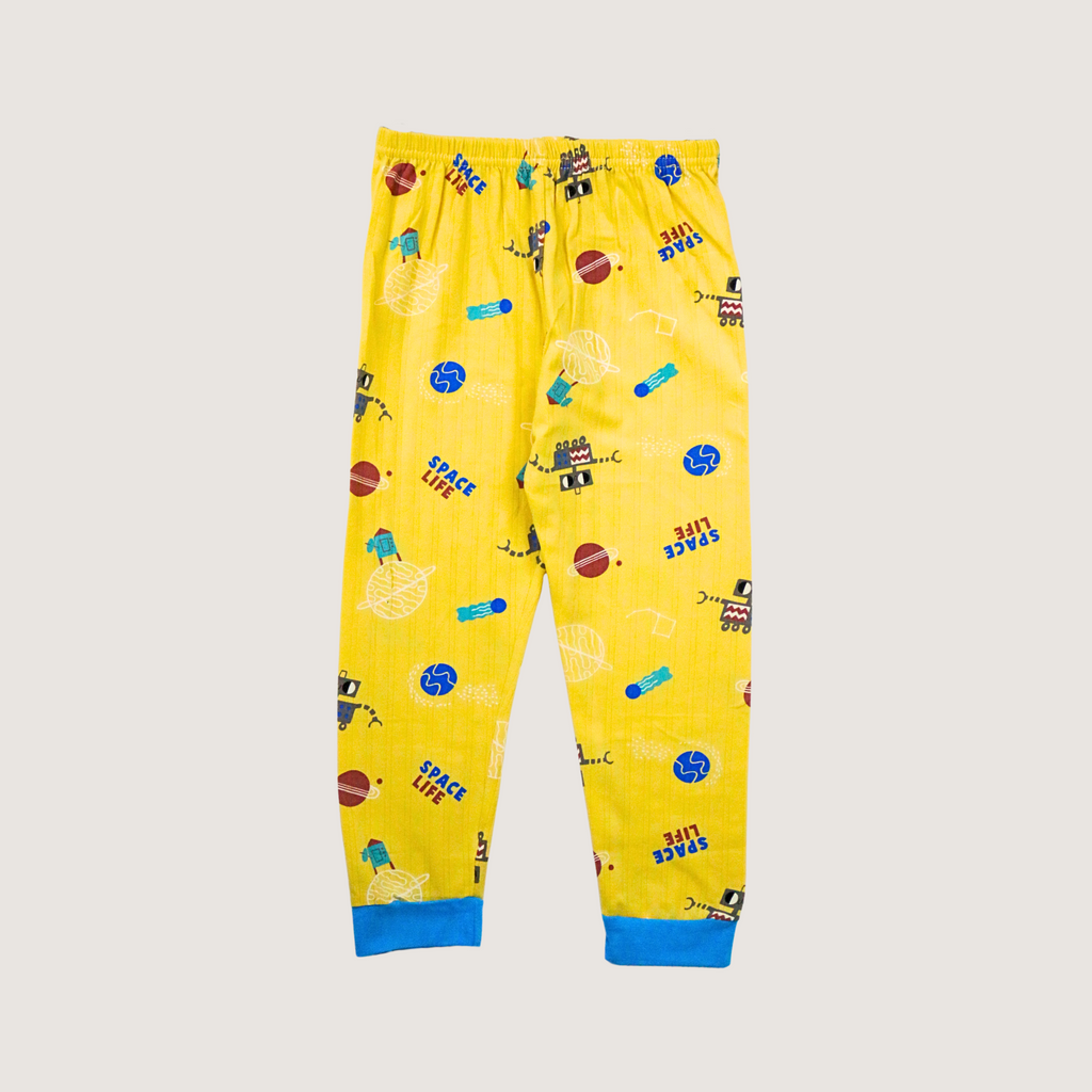 Yellow children's pajama pants with space-themed print on a beige background
