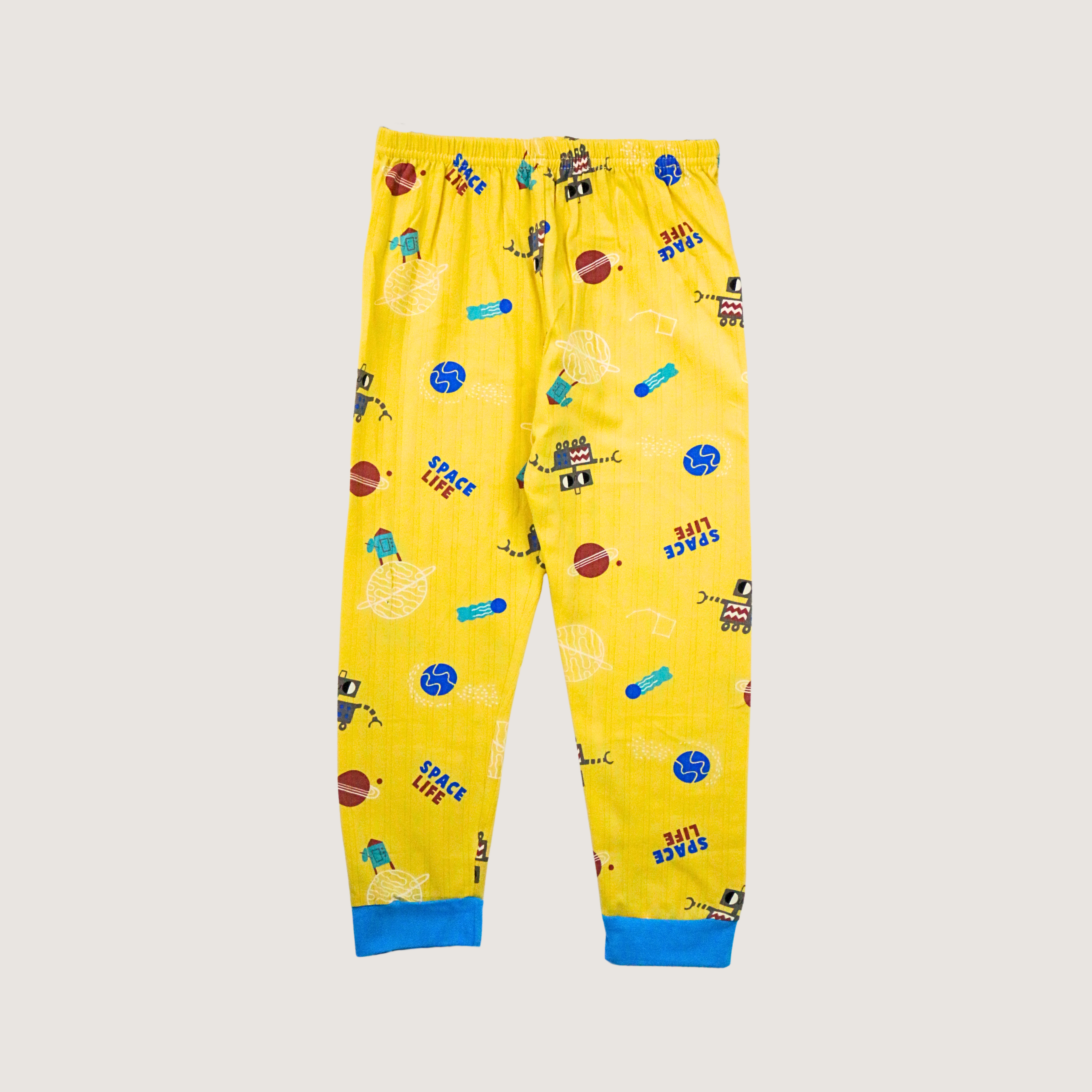 Yellow children's pajama pants with space-themed print on a beige background