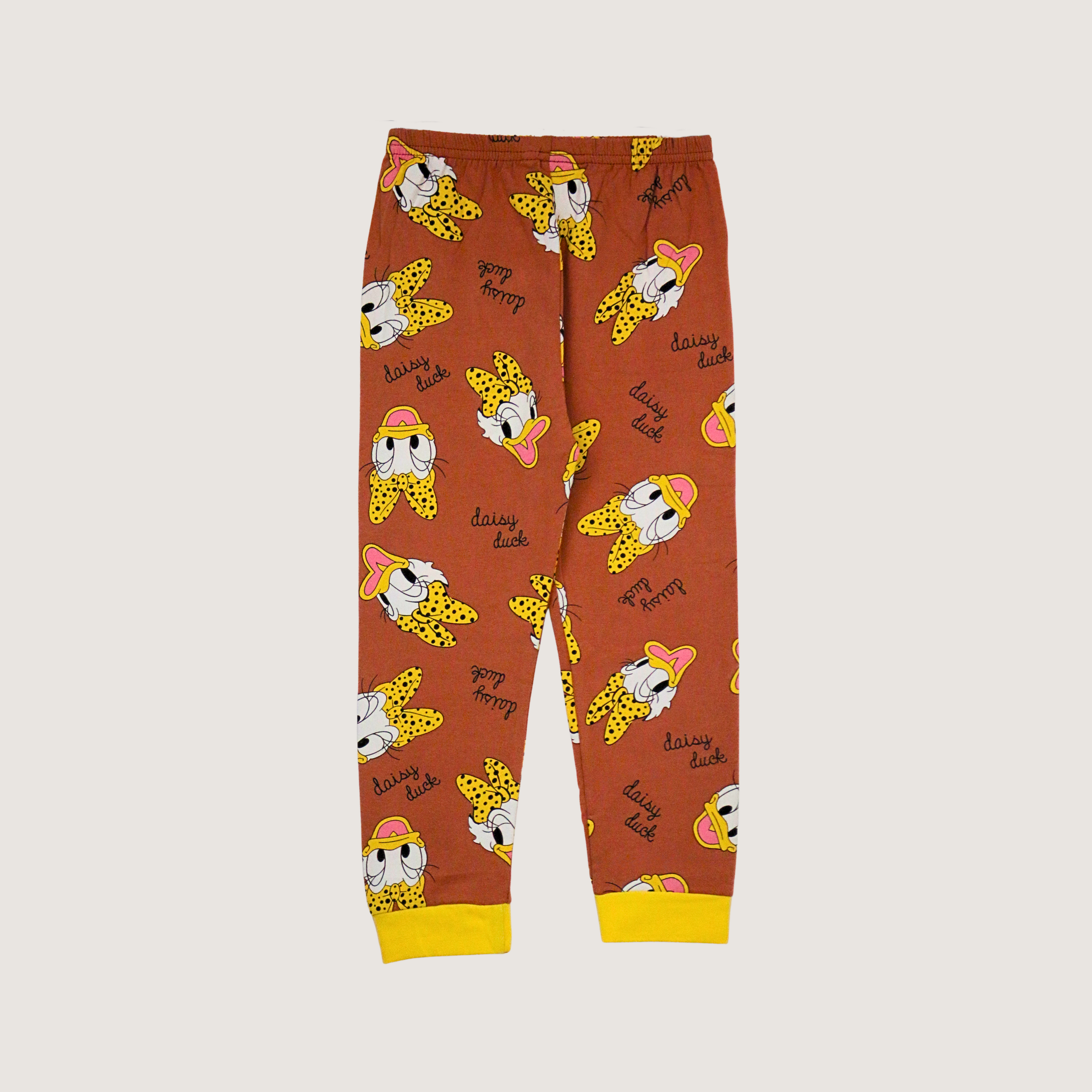 Children's pajama pants with cartoon character pattern on a beige background