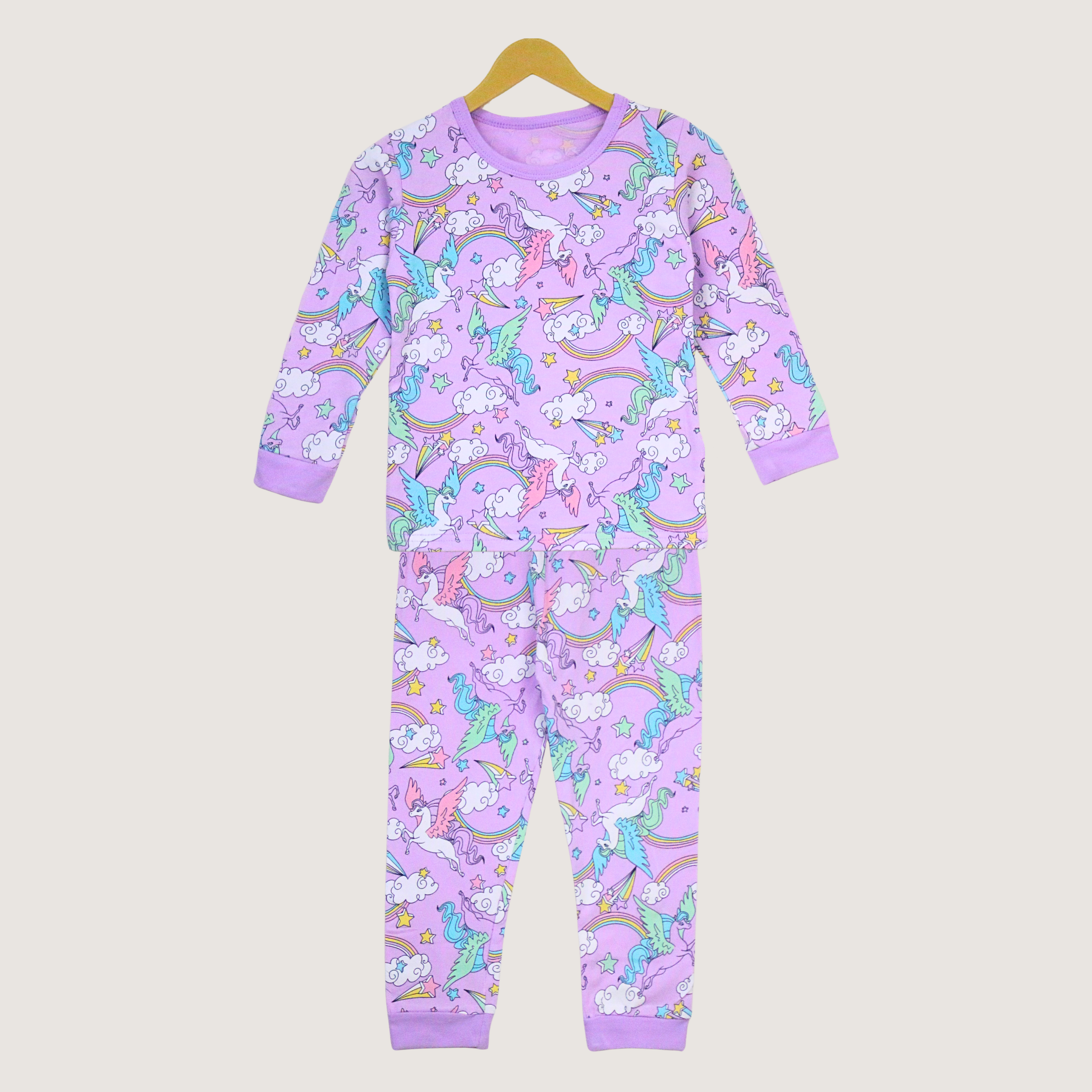 Children's onesie with unicorn and rainbow pattern on a beige background
