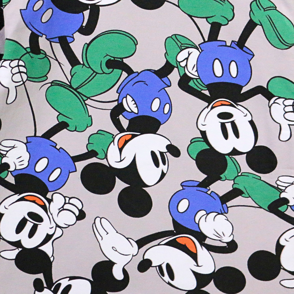 Pattern of cartoon characters with blue, green, and black colors on a light gray background.