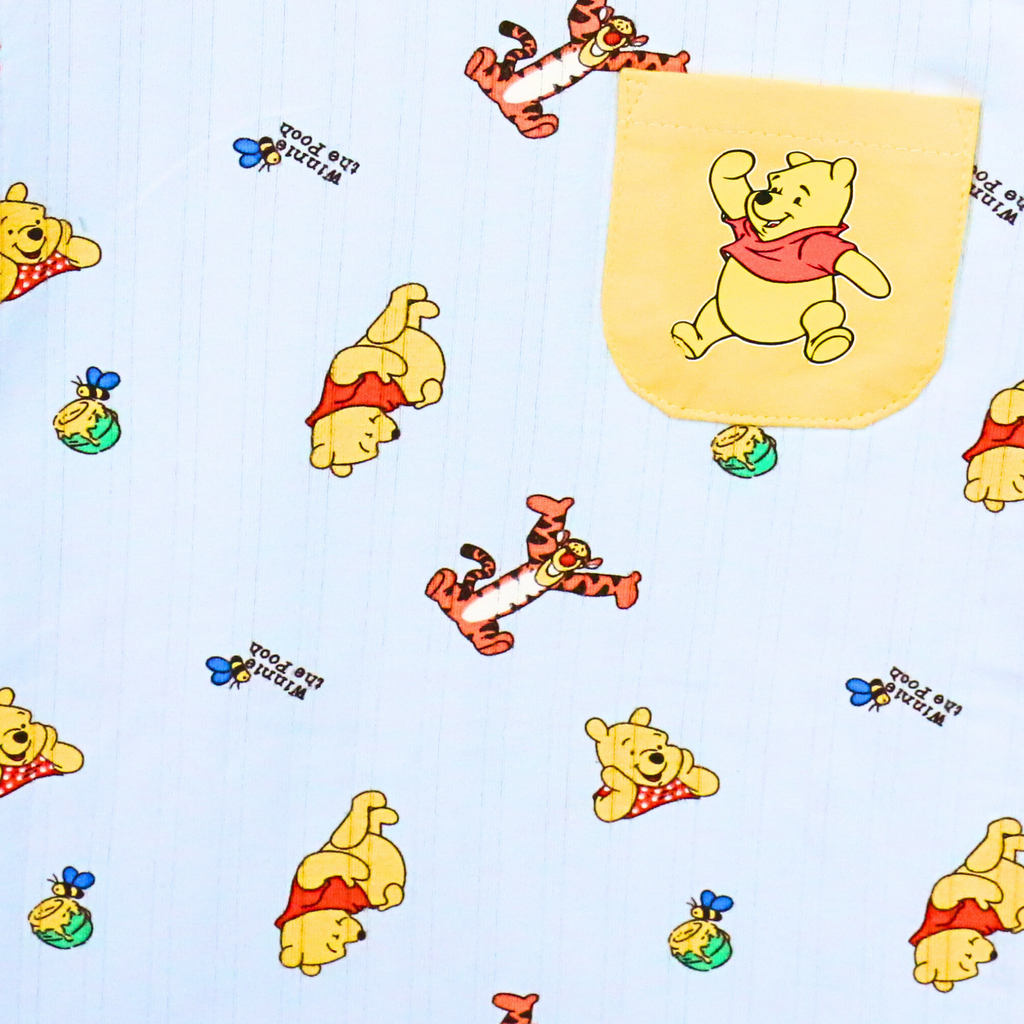 Pattern of cartoon characters including a bear and tiger on a light blue background.