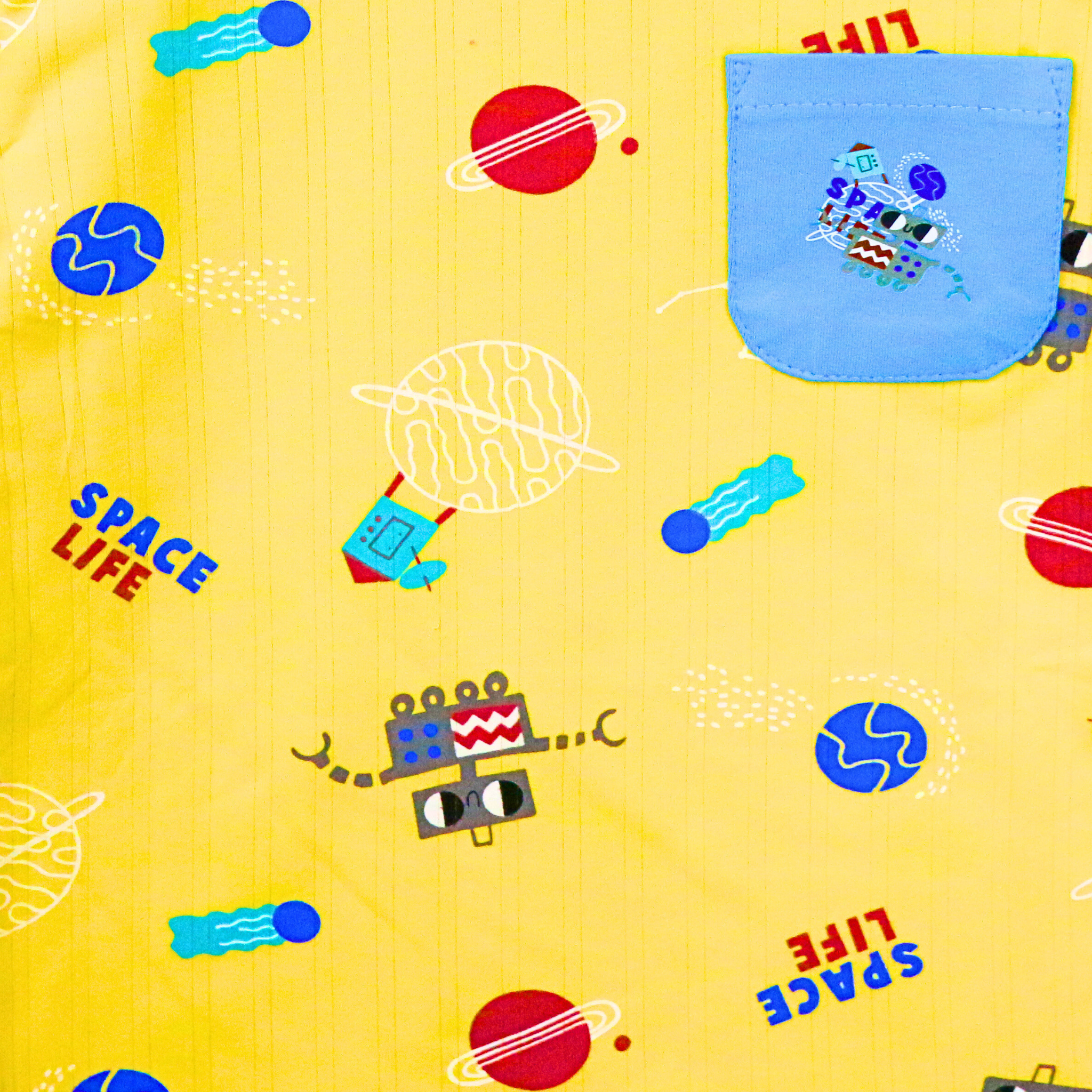 Children's fabric with space-themed patterns and text on a yellow background