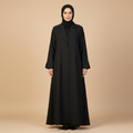 Woman wearing a black abaya on a beige background