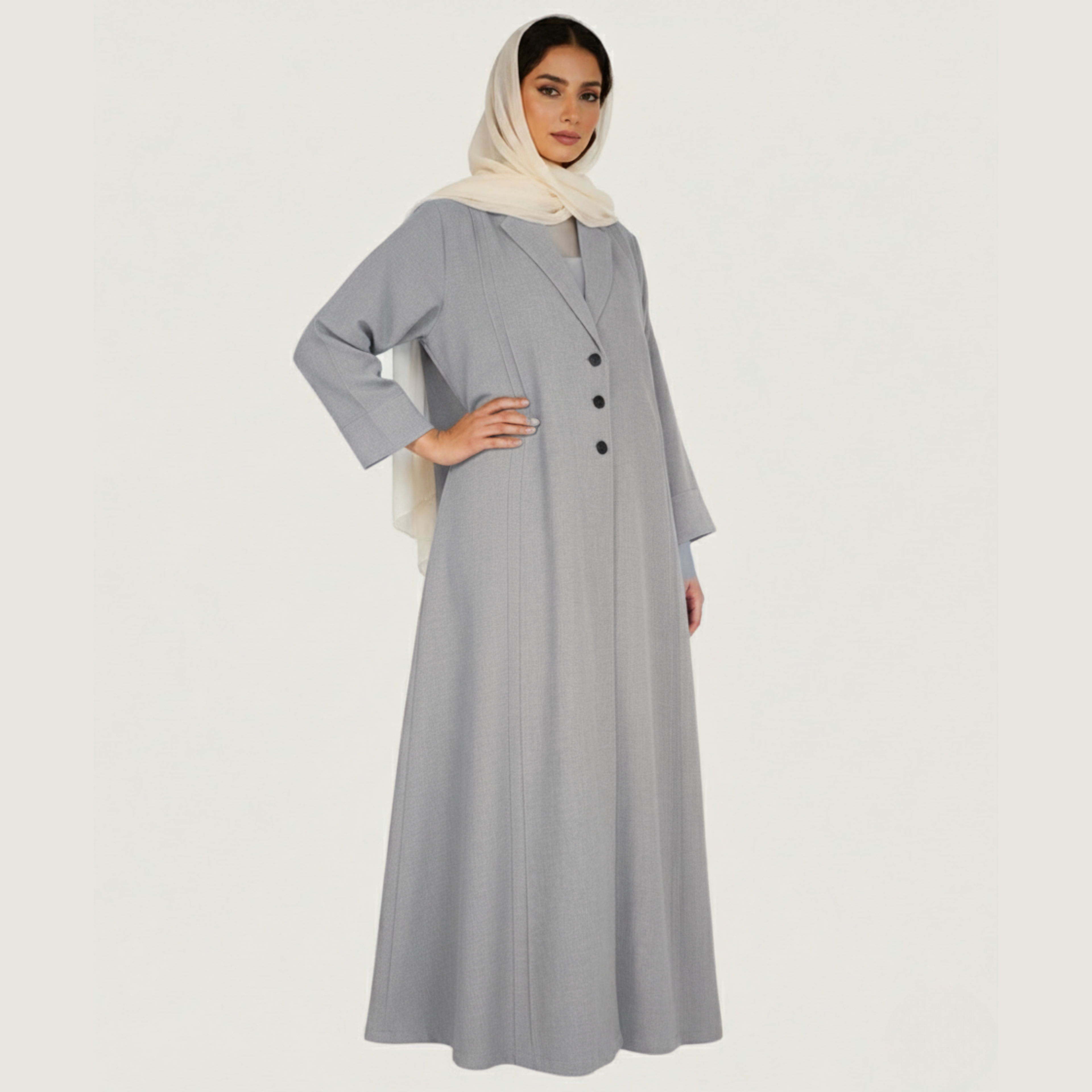 Woman wearing a long gray dress with buttons on a white background